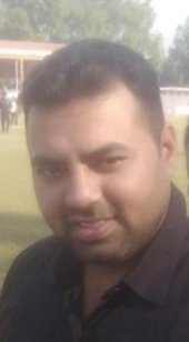 Portrait of Dr. Kapoor wearing traditional attire with academic books in background