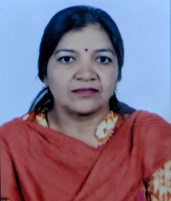 Portrait of Dr. Kapoor wearing traditional attire with academic books in background