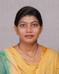Portrait of Dr. Kapoor wearing traditional attire with academic books in background