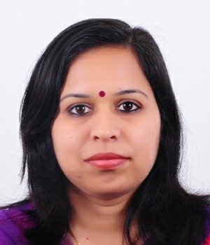 Portrait of Dr. Kapoor wearing traditional attire with academic books in background
